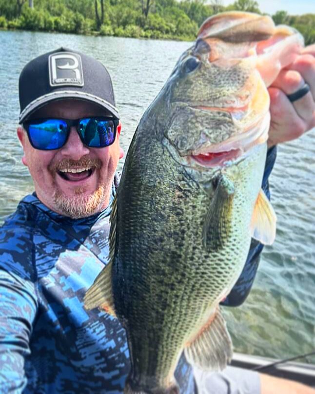 Two anglers on the bank in Reeled In hats