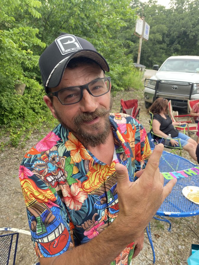 Customer at a lakeside cookout in a Reeled In hat
