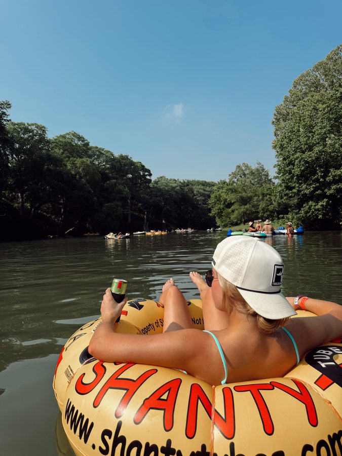 Two customers tubing the river in Reeled In hats